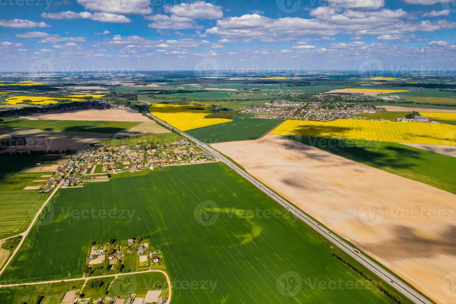 top view of a sown green field and a small village in Belarus. Agricultural fields in the village.Spring sowing in a small village photo