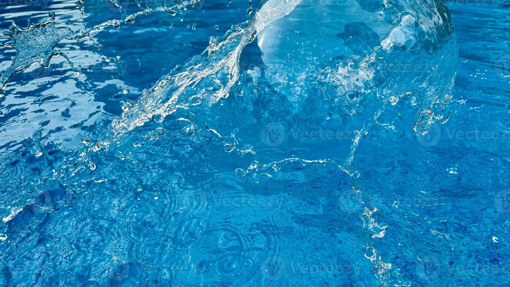 Background dynamic splash of clear water creating swirling wave in blue water with droplets suspended in motion. Clean water concept. photo