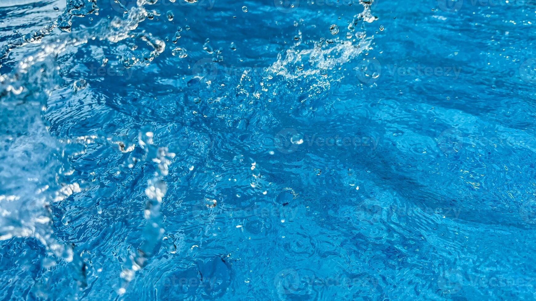 Background dynamic splash of clear water creating swirling wave in blue water with droplets suspended in motion. Clean water concept. photo