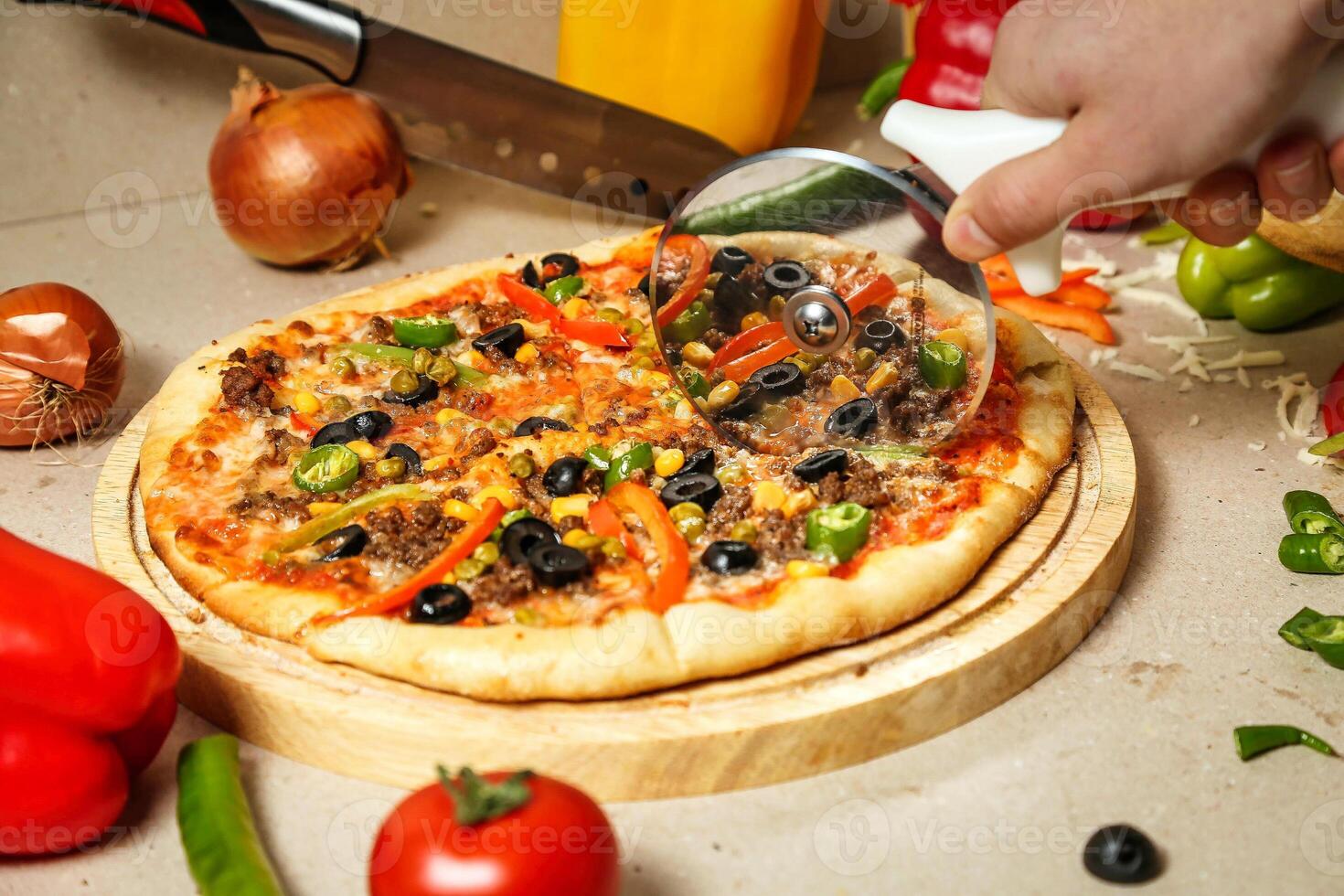Person Cutting Pizza With Pizza Cutter photo
