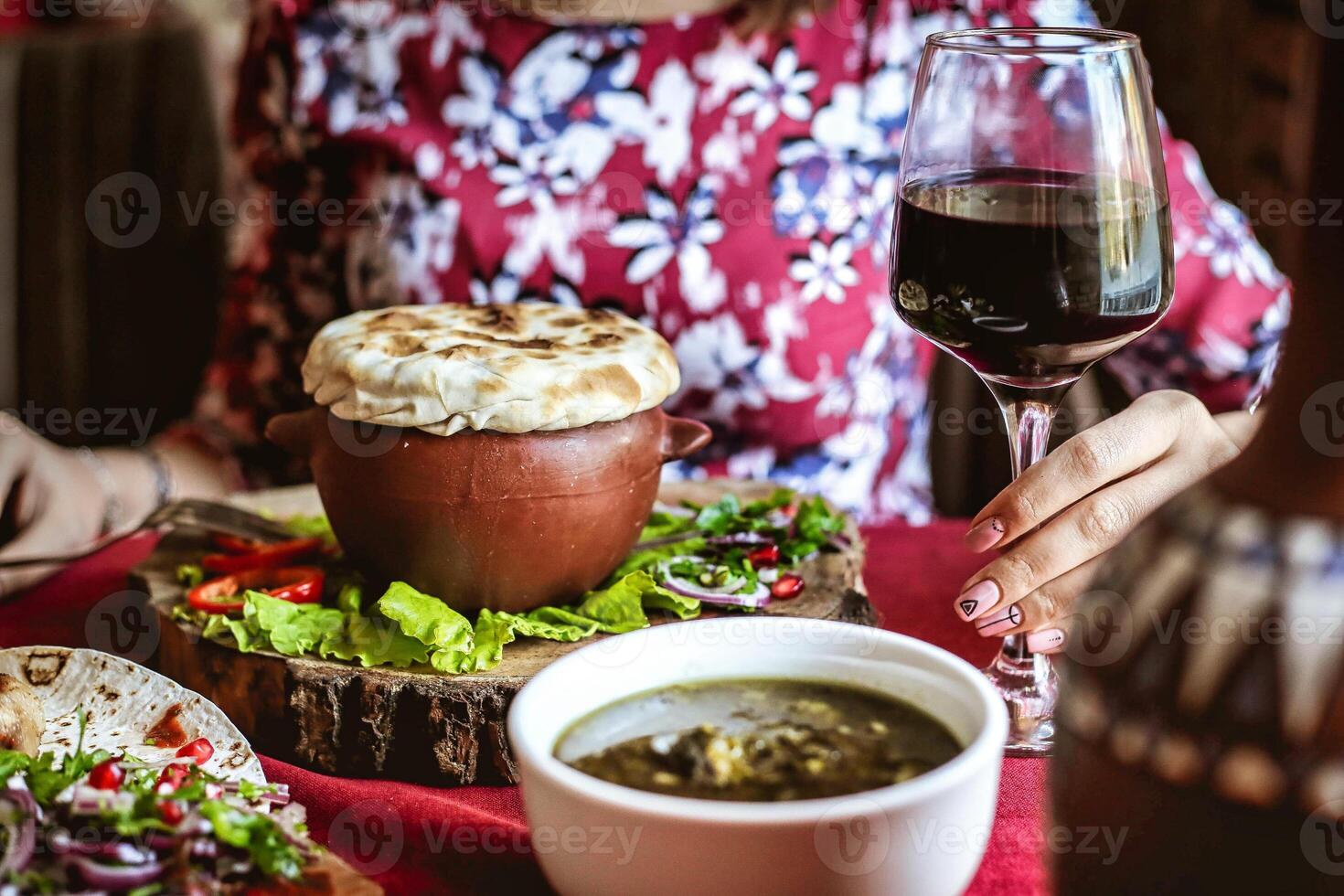 Woman Holding Glass of Wine and Plate of Food at Restaurant photo