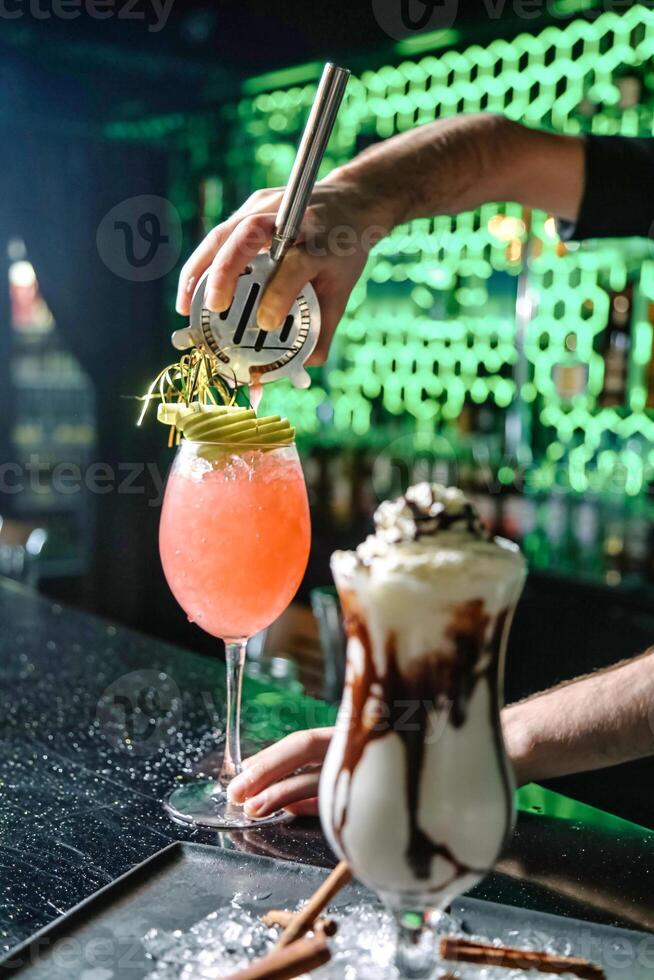 Bartender Pouring a Cocktail Into Glass at the Bar Counter photo