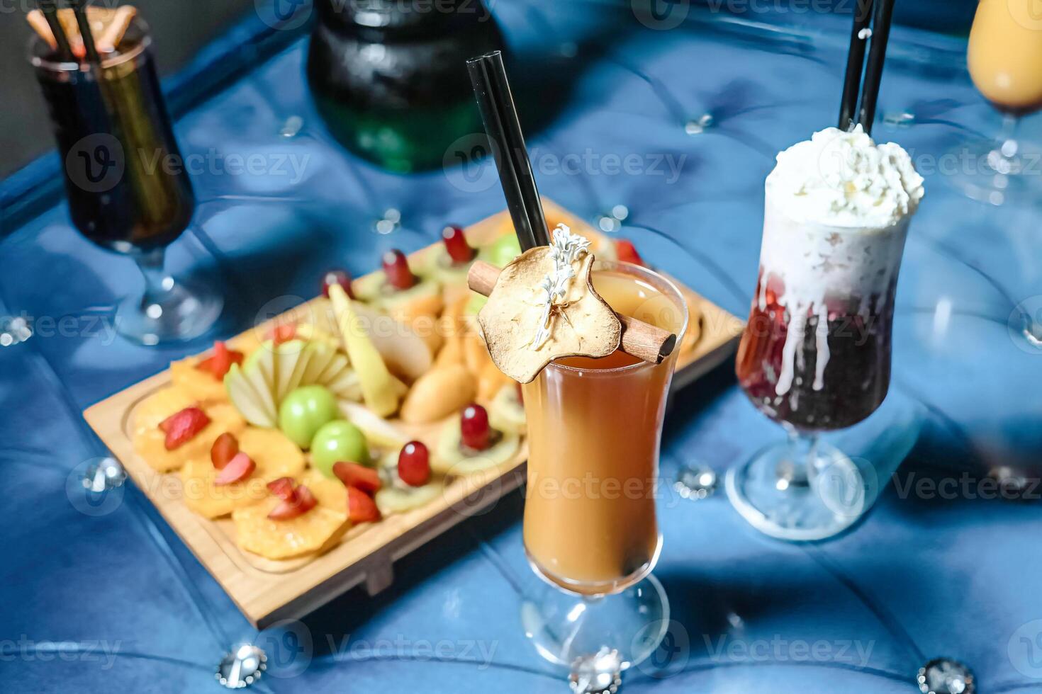 Blue Table With Two Drinks and a Plate of Fruit photo