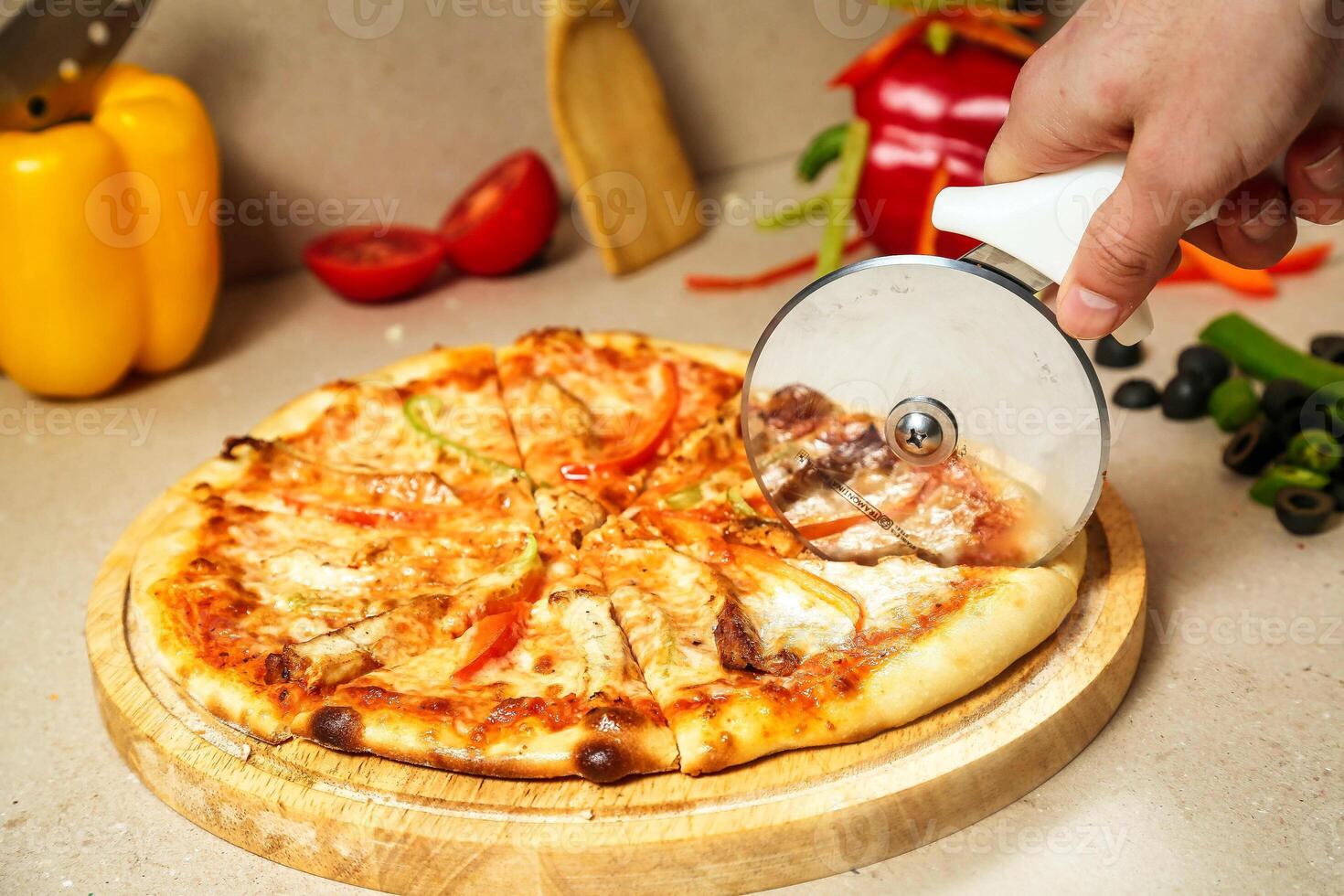 Pizza Being Cut Using a Pizza Cutter photo