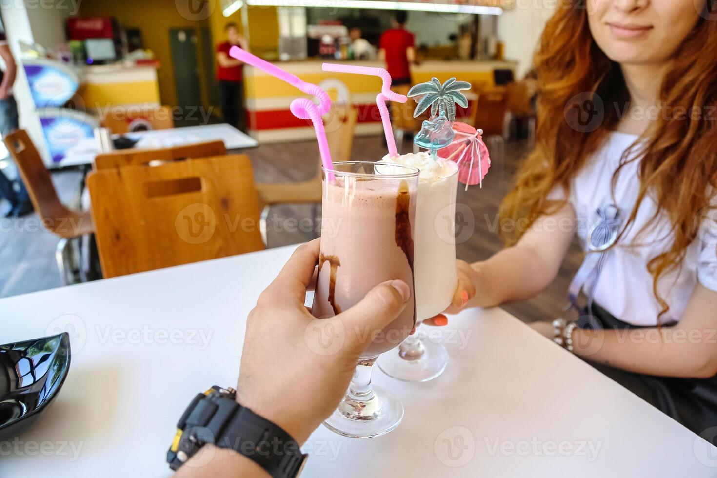 Woman Sitting at Table With Drink in Hand photo