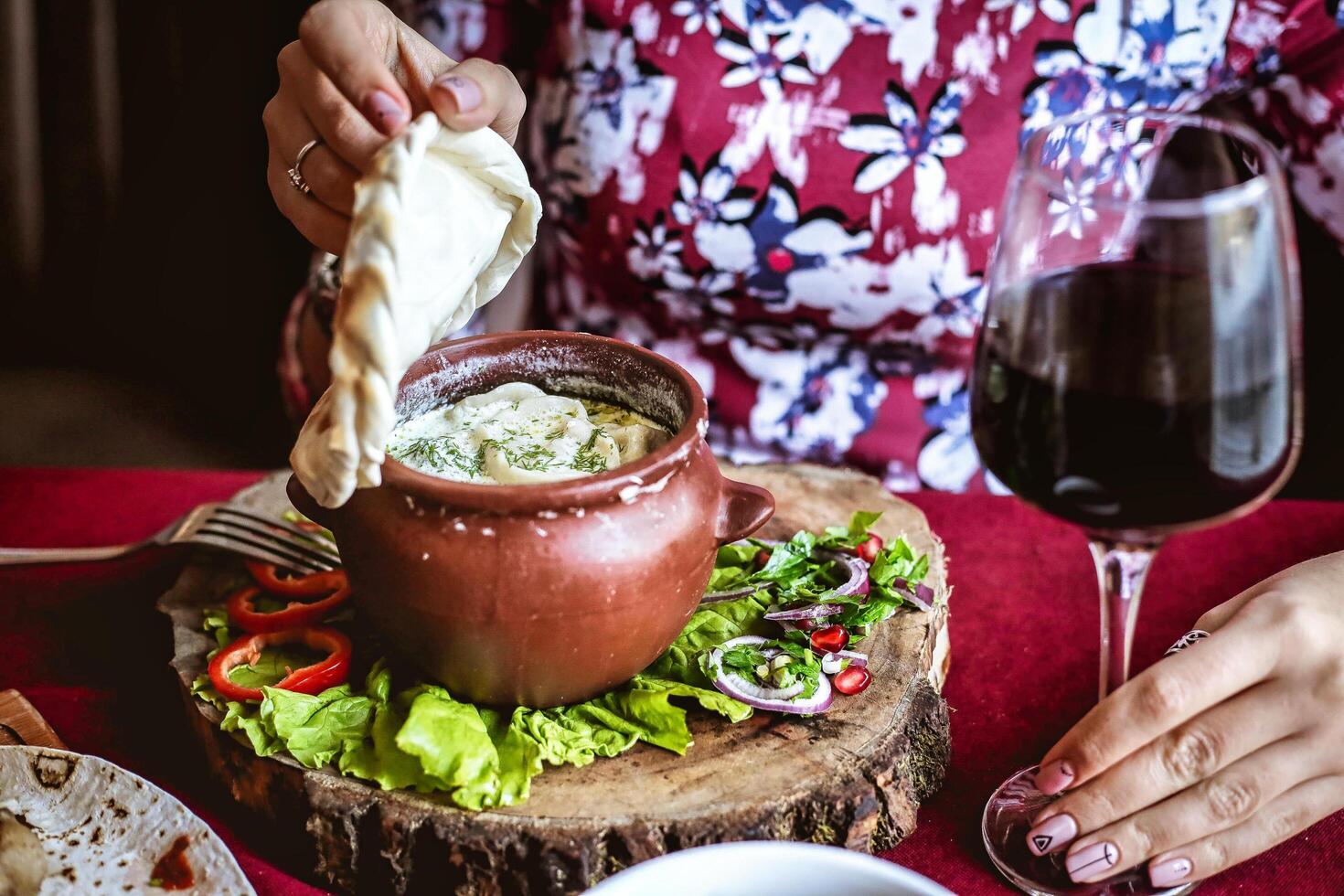 Woman Sitting at Table With Plate of Food and Glass of Wine photo