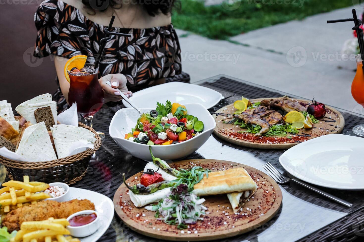 Woman Sitting at Table With Various Plates of Food photo
