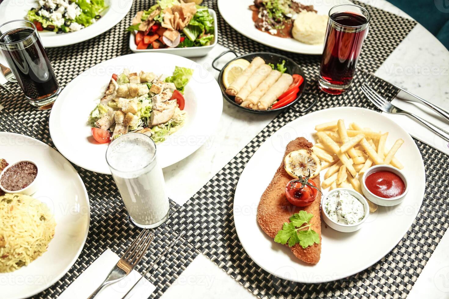 Table Adorned With Plates of Savory Food and Refreshing Beverages photo