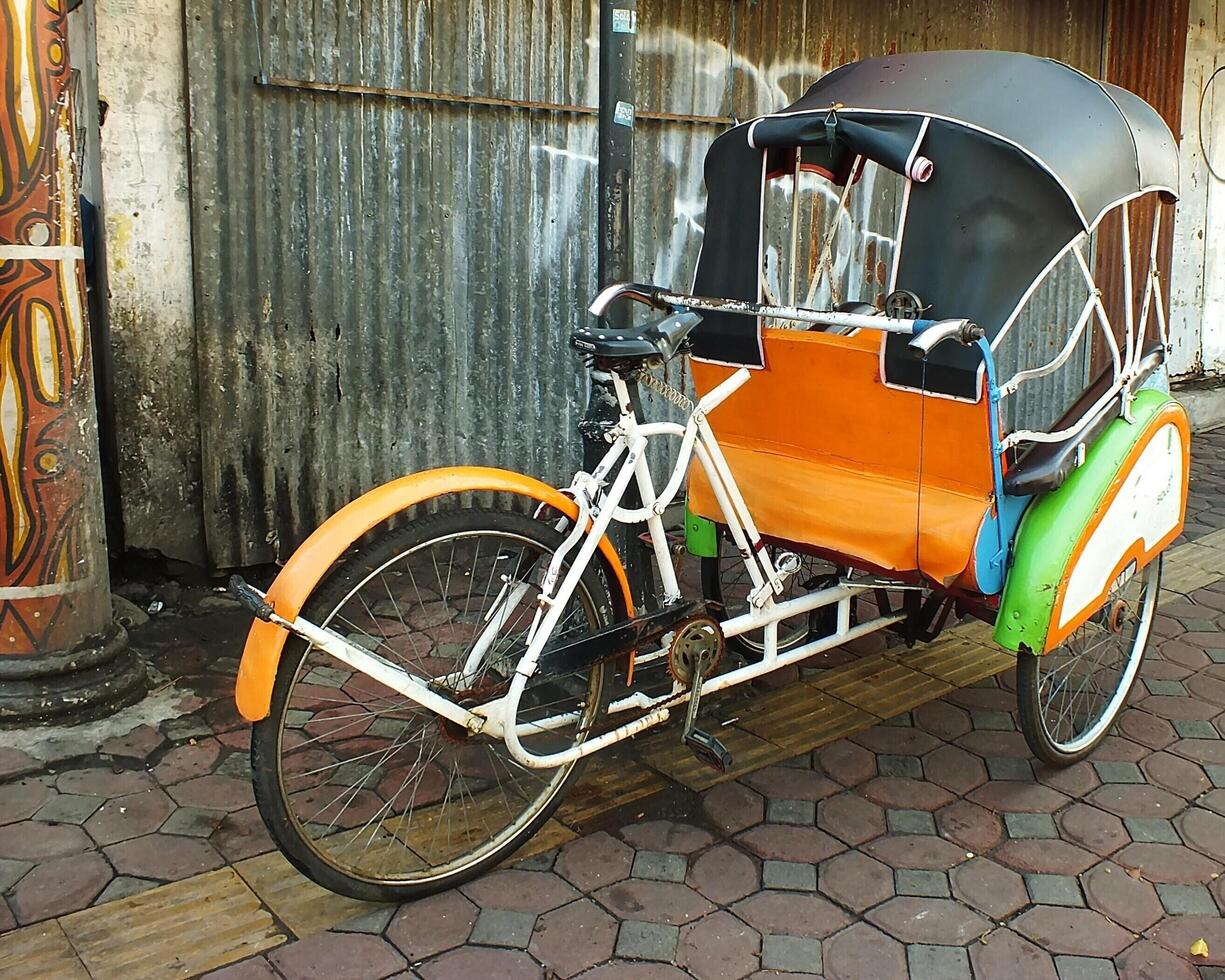 Surakarta, Central Java, Indonesia April 11, 2024. Vintage Becak vehicle is a traditional public transportation from Indonesia. photo