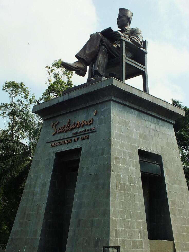 Surakarta, Central Java, Indonesia April 11, 2024. The statue of Mr Soekarno sitting while reading a book, statue of the first president of The Republik Indonesia at Manahan Stadium. photo