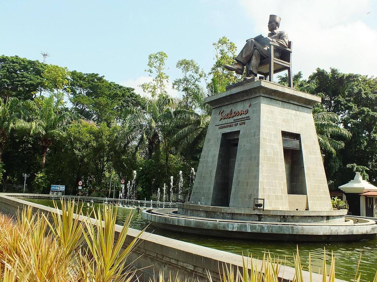 Surakarta, Central Java, Indonesia April 11, 2024. The statue of Mr Soekarno sitting while reading a book, statue of the first president of The Republik Indonesia at Manahan Stadium. photo