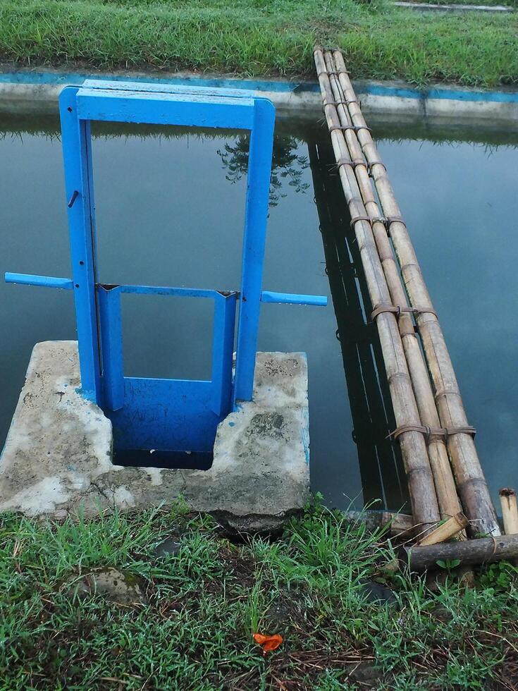 irrigation channel with blue metal door for rice fields photo