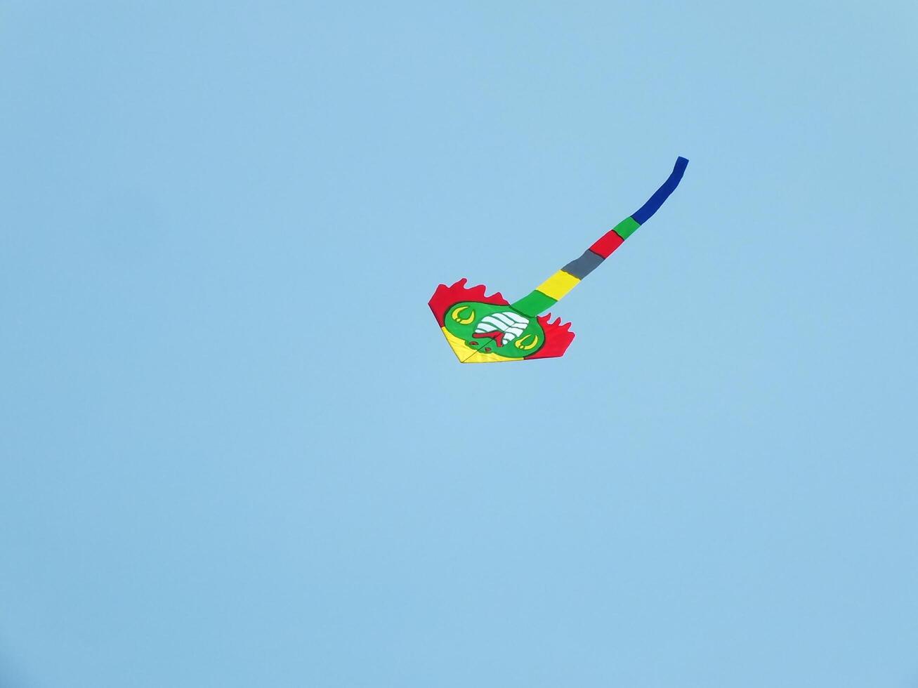 Beautiful kite flies in a clear and blue sky on a sunny day. enjoy the wind. photo