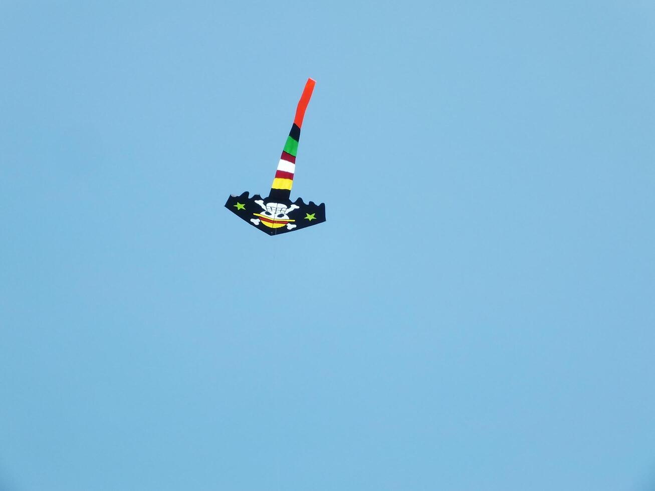 Beautiful kite flies in a clear and blue sky on a sunny day. enjoy the wind. photo