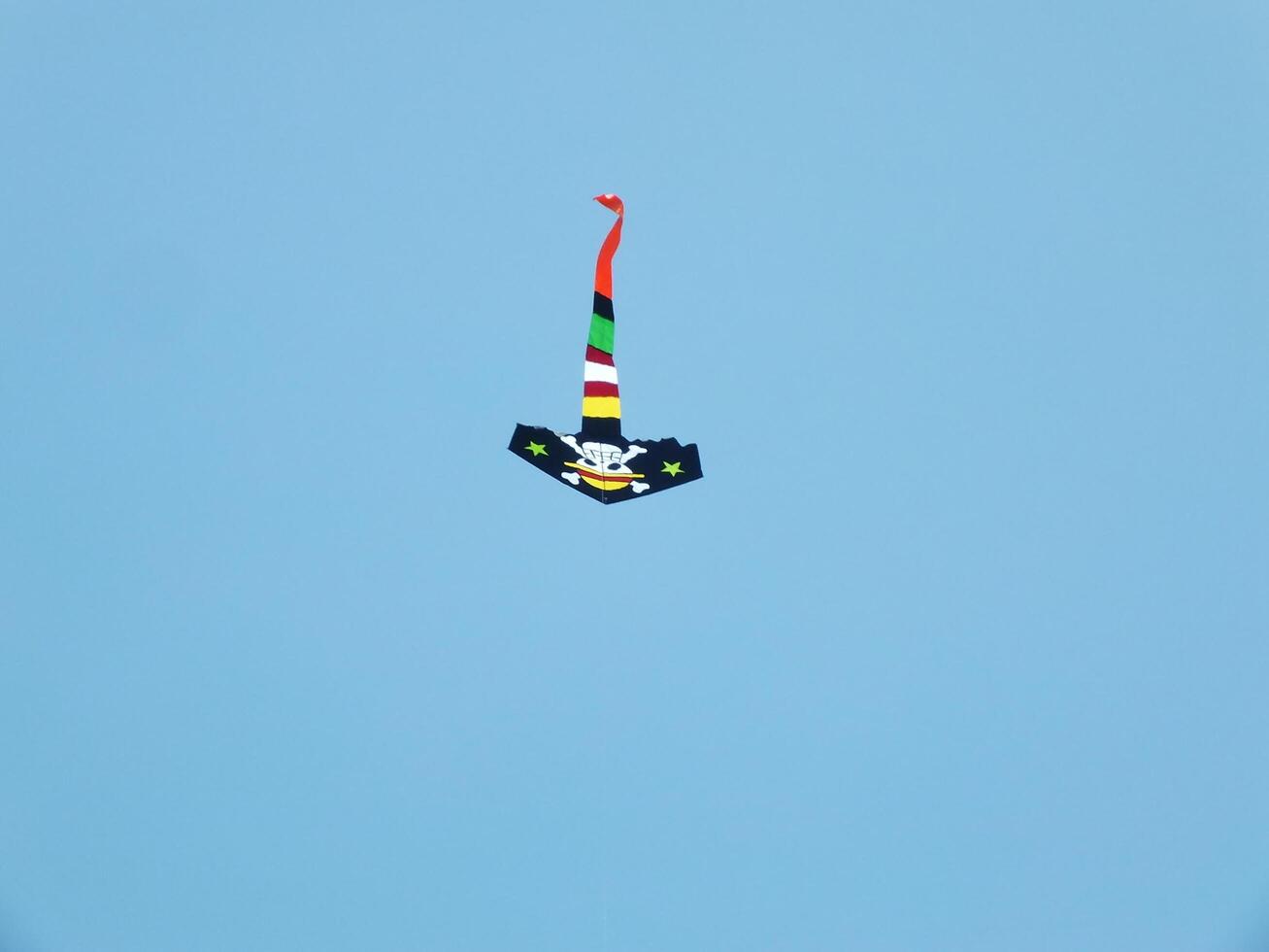 Beautiful kite flies in a clear and blue sky on a sunny day. enjoy the wind. photo