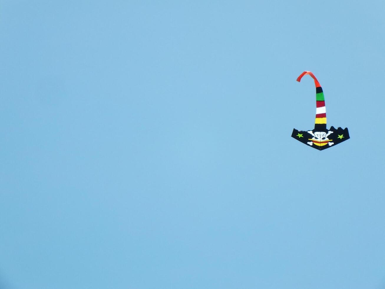 Beautiful kite flies in a clear and blue sky on a sunny day. enjoy the wind. photo