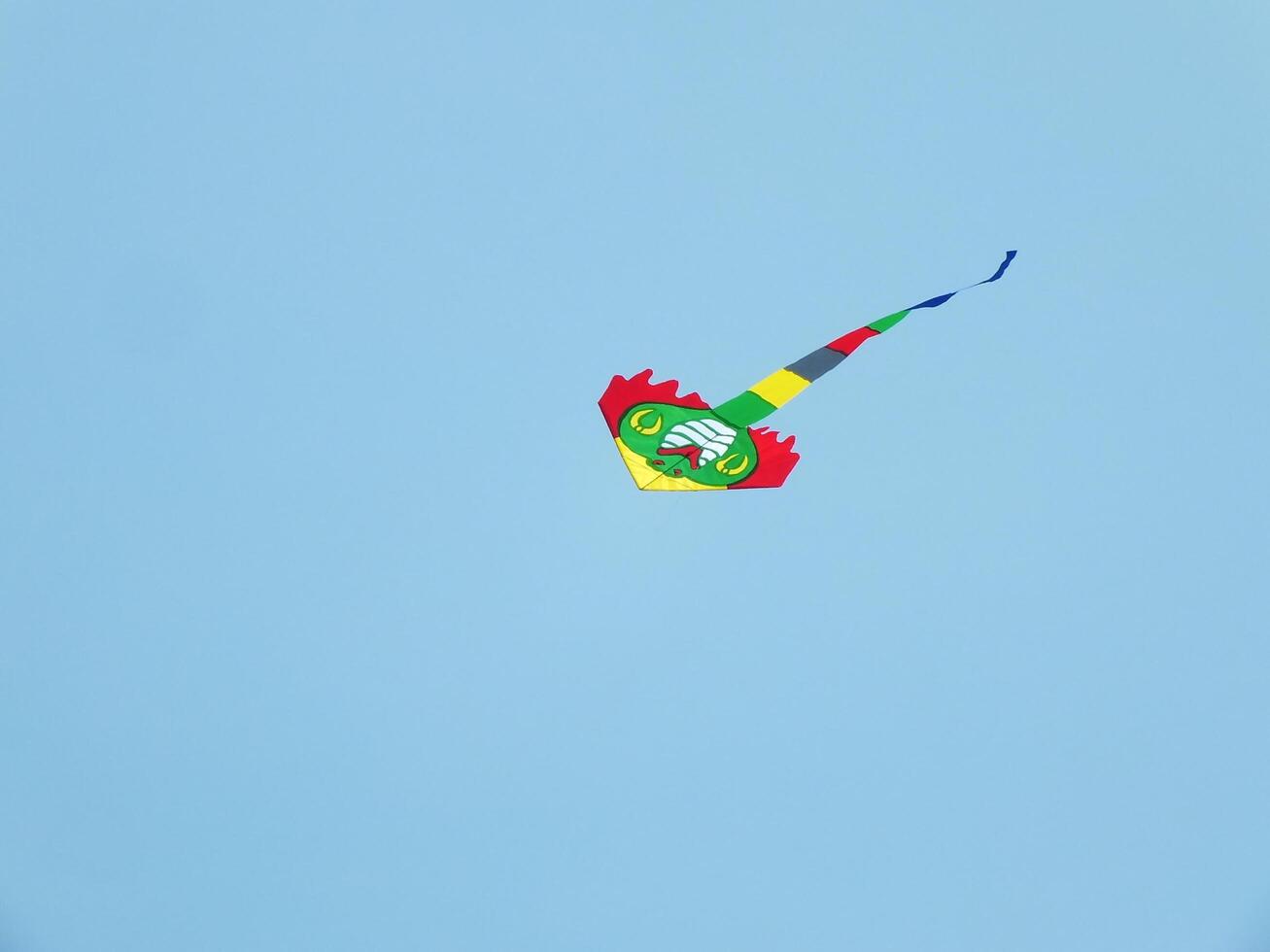 Beautiful kite flies in a clear and blue sky on a sunny day. enjoy the wind. photo