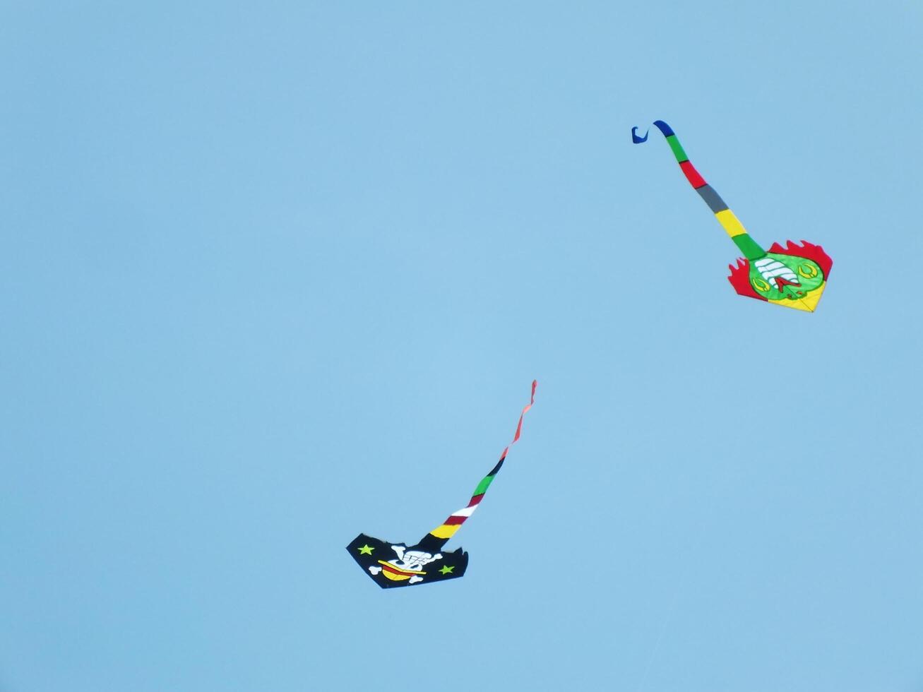 Beautiful kite flies in a clear and blue sky on a sunny day. enjoy the wind. photo