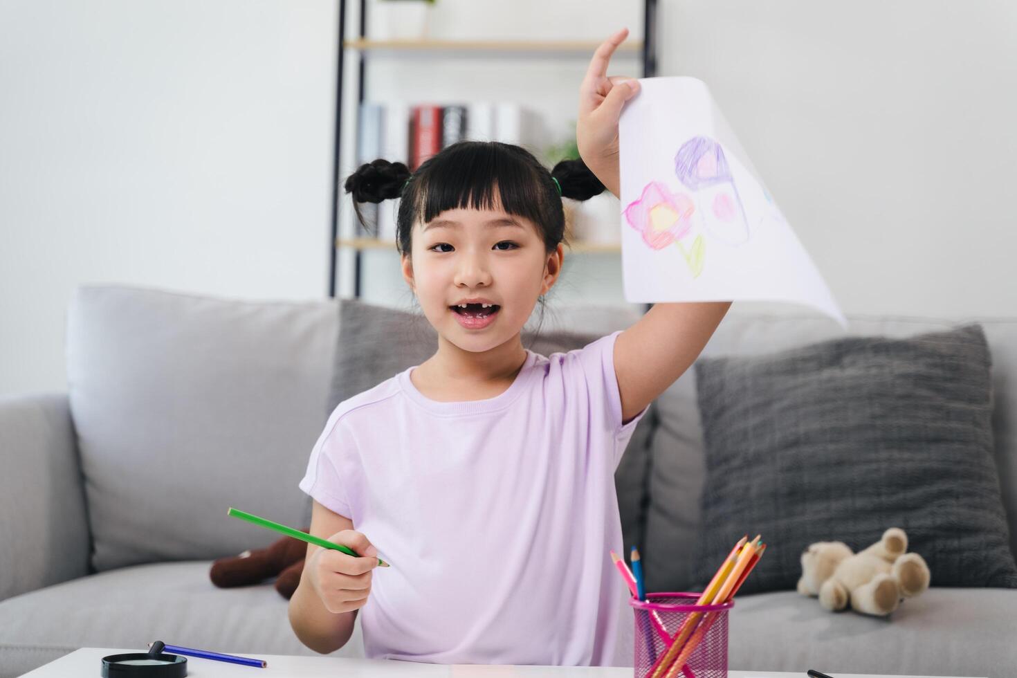 A young girl is drawing a picture on a piece of paper photo