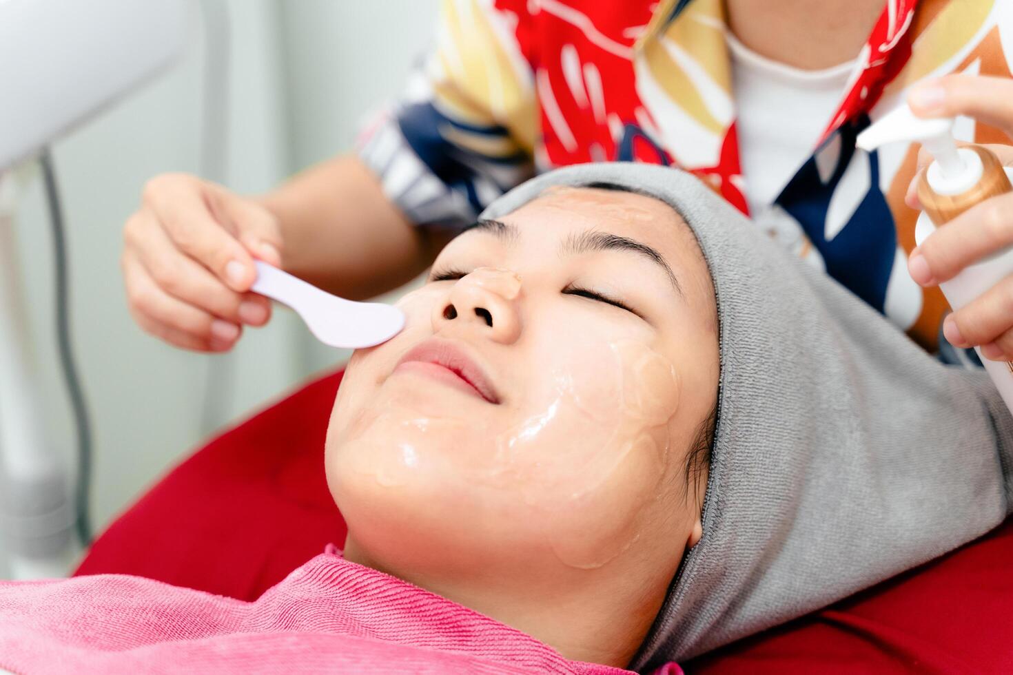 Beauticians perform ultrasound facial procedures with equipment. Woman getting facial massage. photo