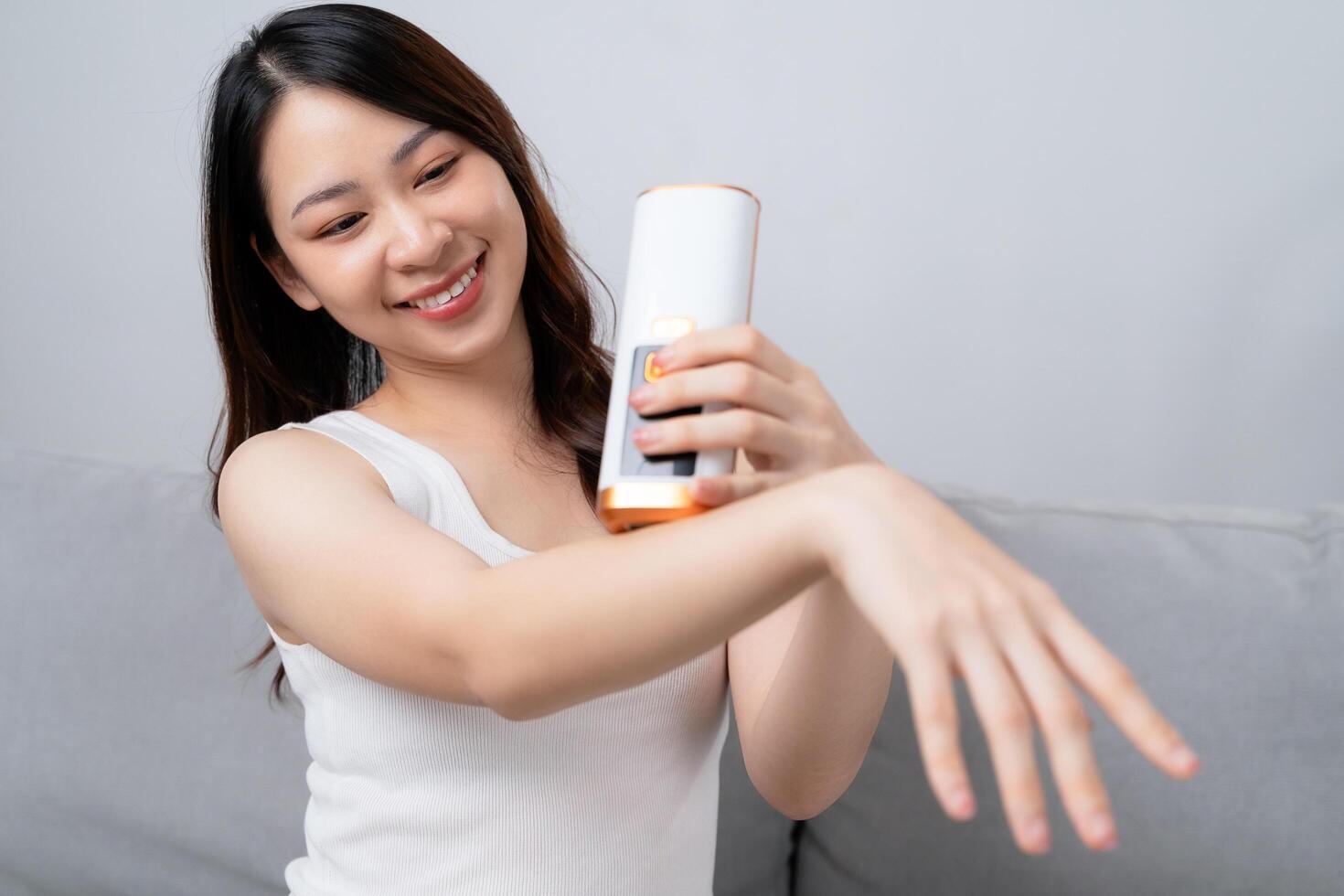 A beautiful woman is epilating and removing hair using an IPL laser hair removal epilator device. photo