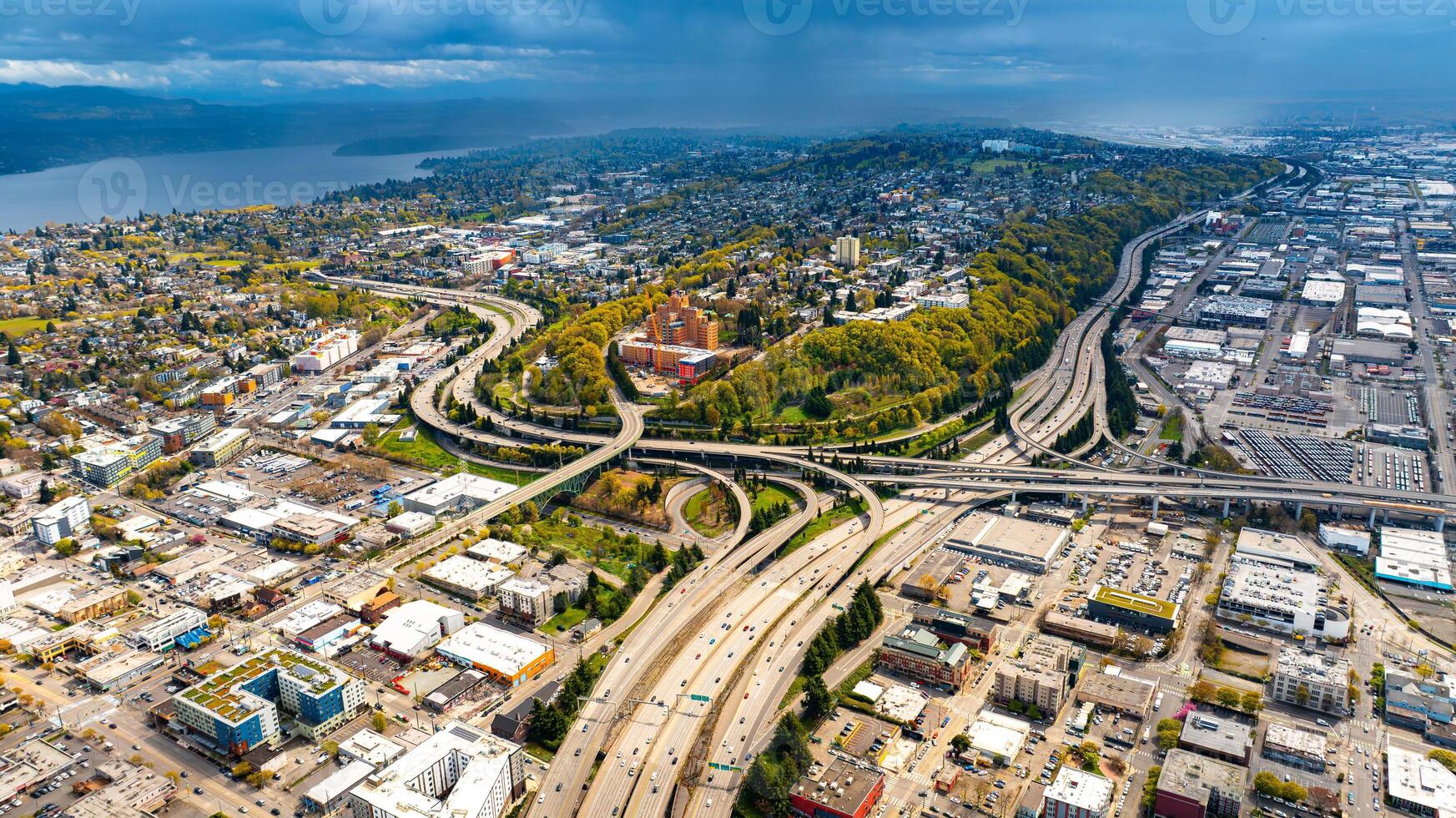 Green neighborhood standing out in the scenery of Seattle, Washington, the USA. Overcast sky above the panorama of metropolis at daytime. photo