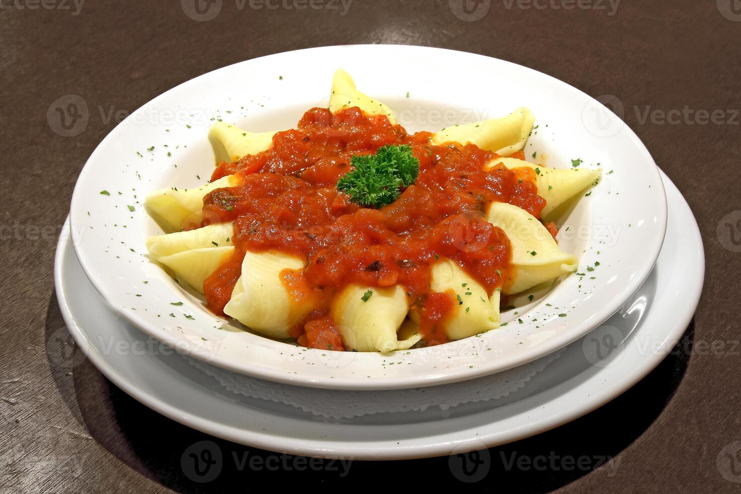 cheese conchiglione with tomato sauce on plate photo
