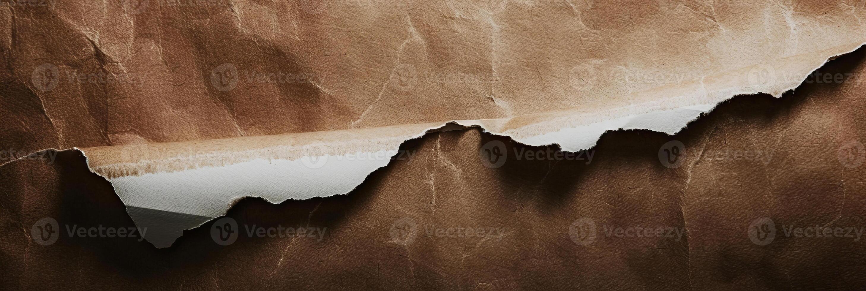 A torn piece of paper with a brown background photo