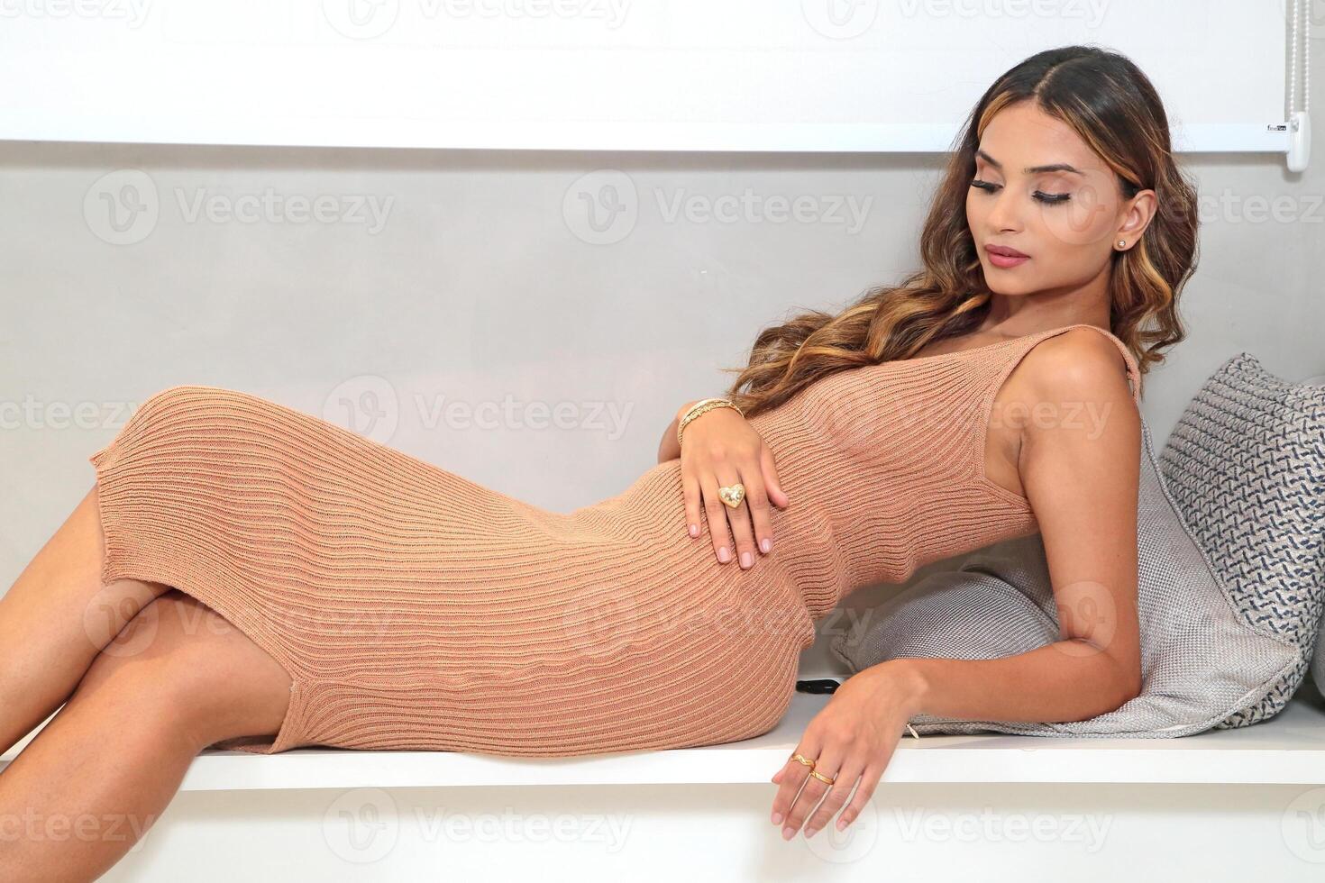 young and beautiful Brazilian model posing in colorful dress and acting with her cell phone photo