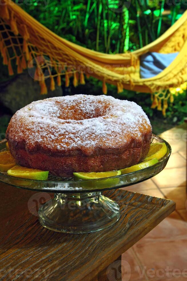 Orange cake with sugar on the table photo