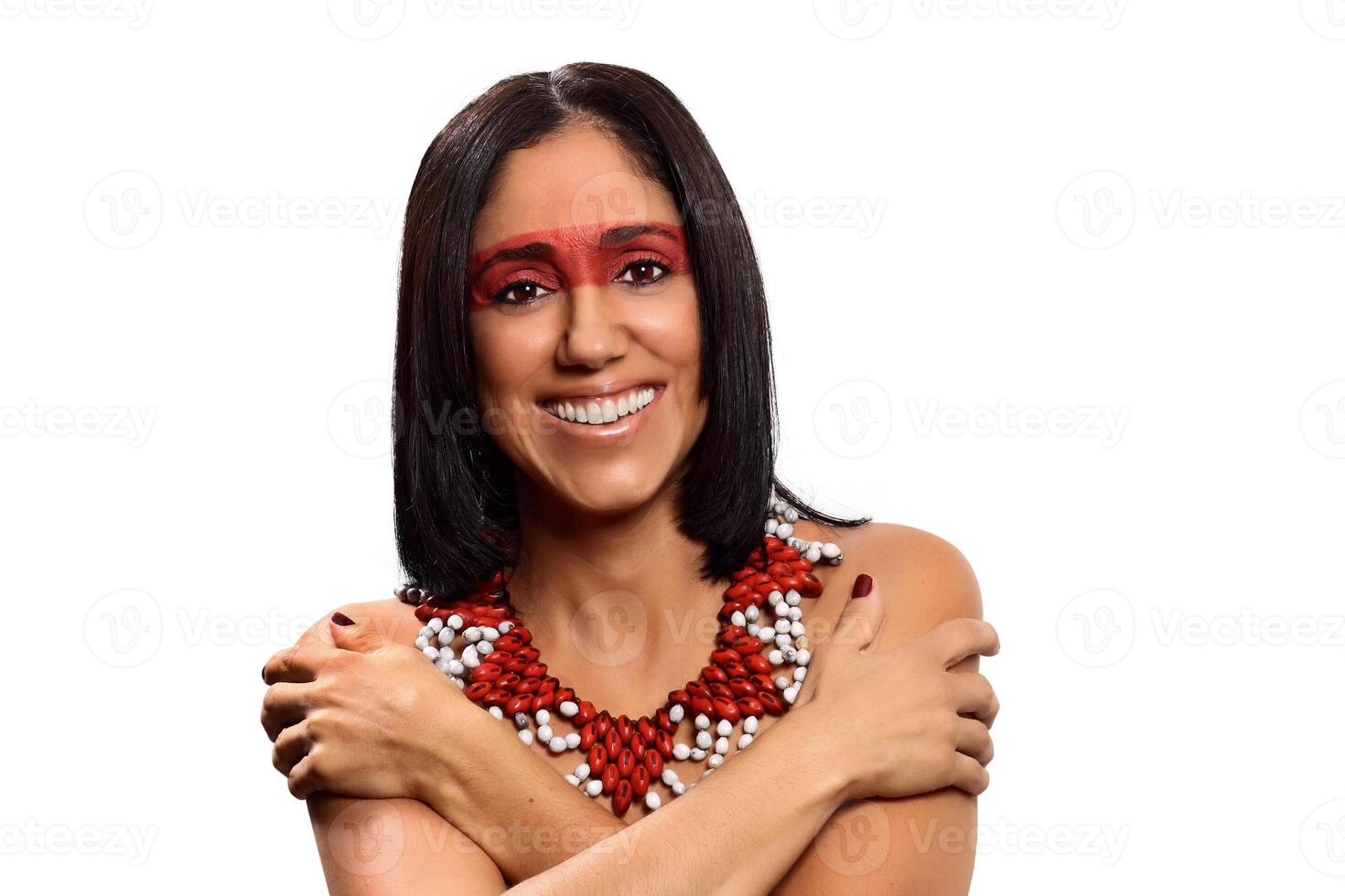 smiling brunette model in Brazilian Indian costume and makeup holding a tapioca, a typical Brazilian snack photo