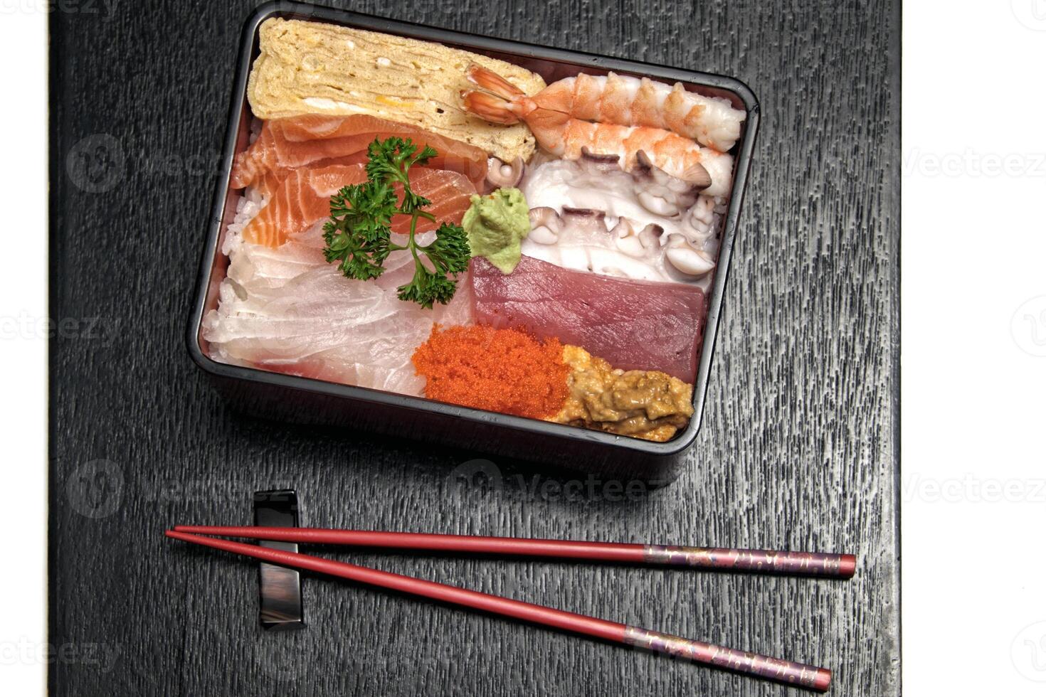 Tirashi, Japanese delicacy with salmon, squid, cucumber, nori, kani kama and salmon roe photo