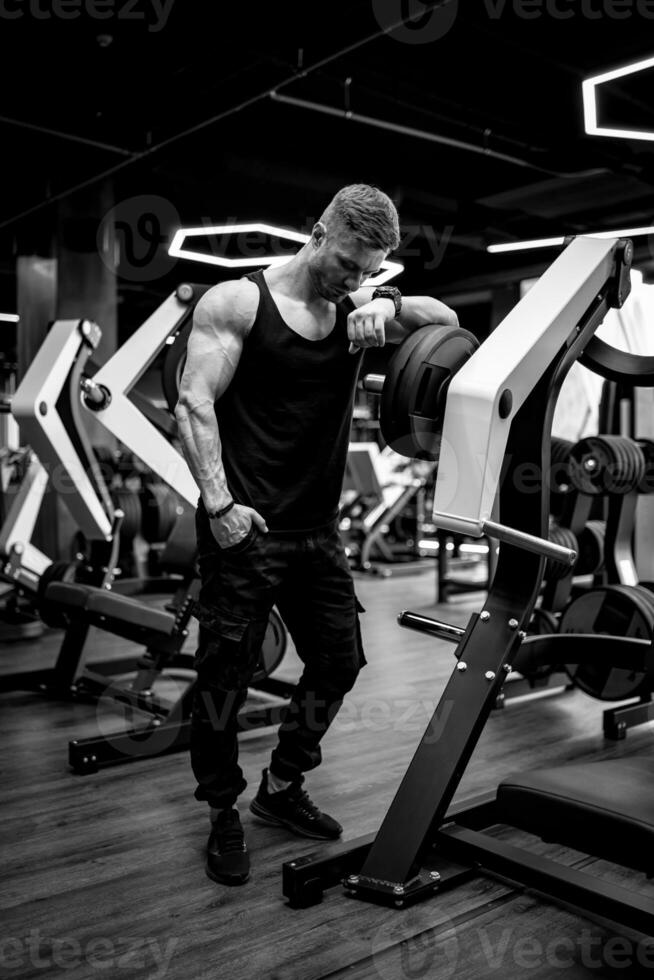 Fitness athlete sporty bodybuilder after training. Strong muscular man having rest after training. photo