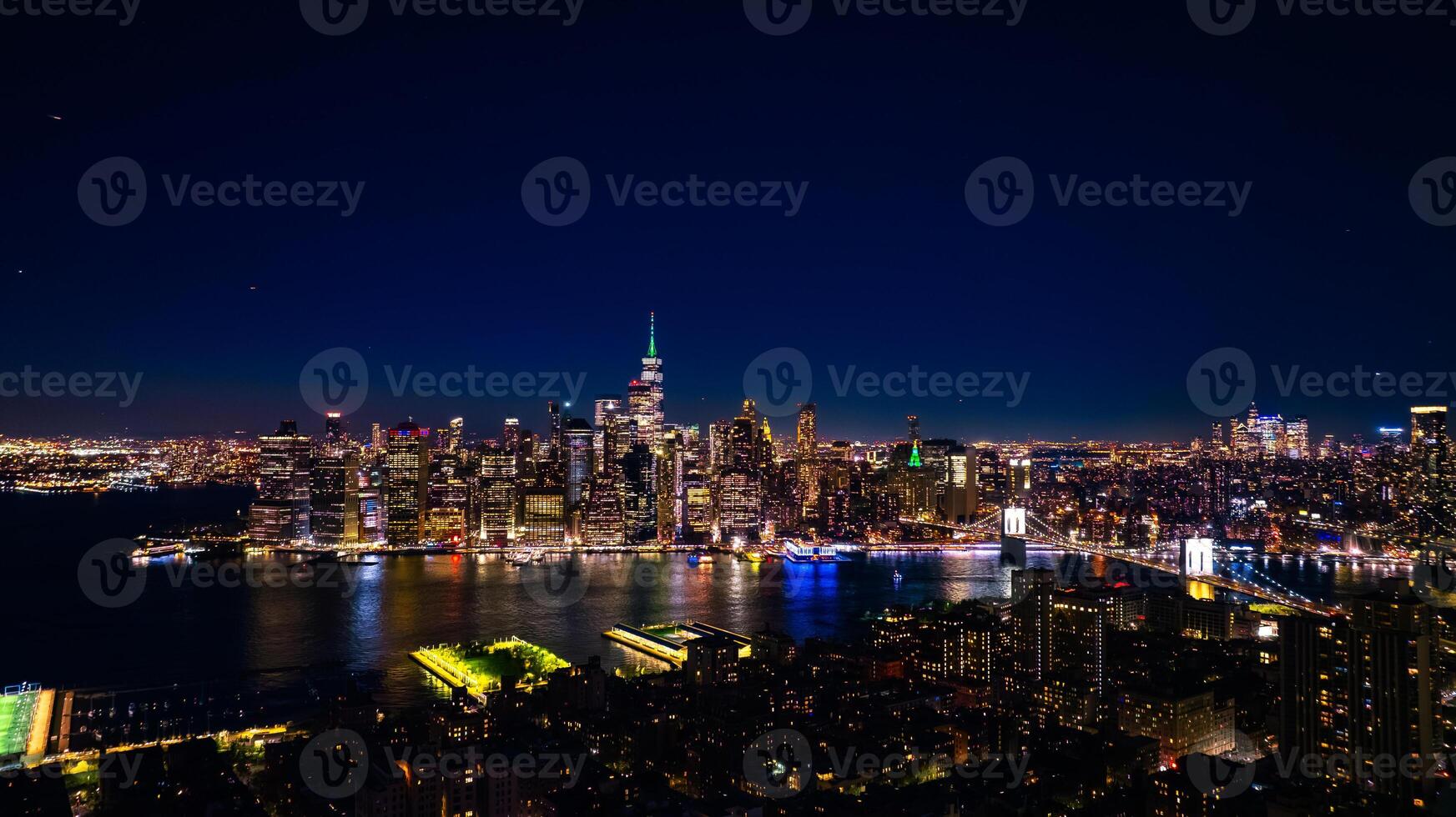 Distancing from a spectacular view of New York, the USA on the waterfront of the East River. Skyline of metropolis at night. Aerial perspective. photo