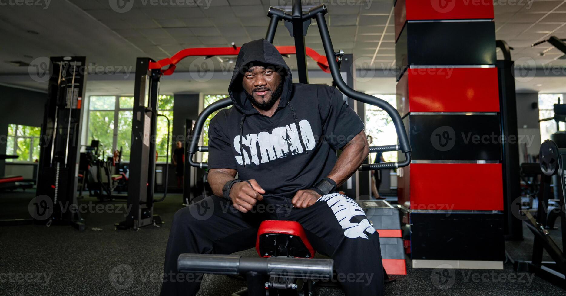 Muscle bodybuilder having rest after training. Strong handsome man training hard in the gym. photo