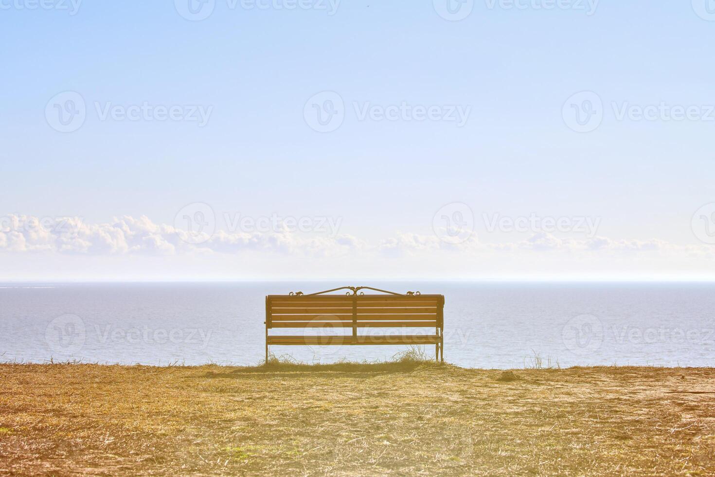 Empty bench on cliff before sea background, peaceful and quiet place for thinking alone photo