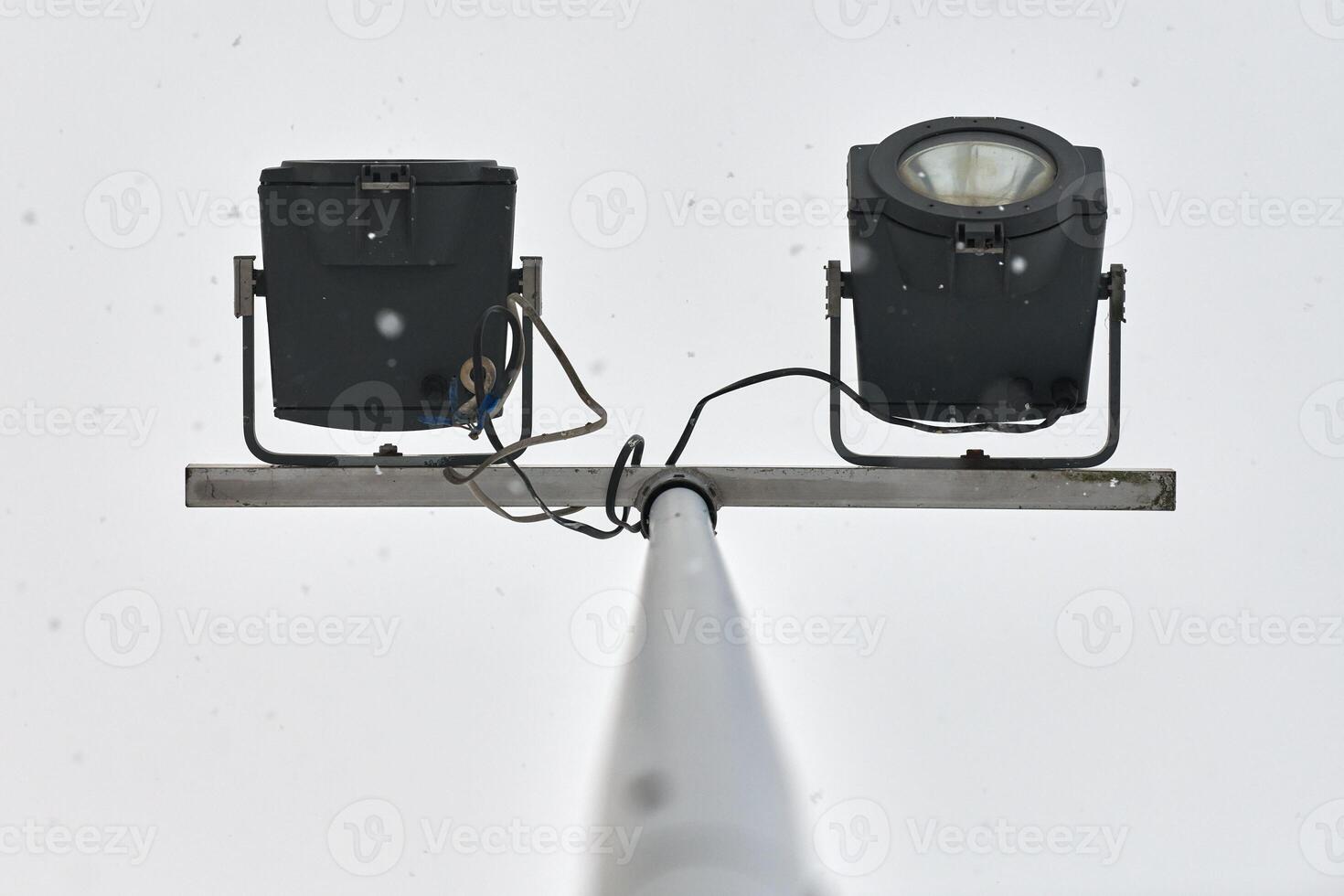 Powerful LED light on metal pole, cloudy grey sky photo