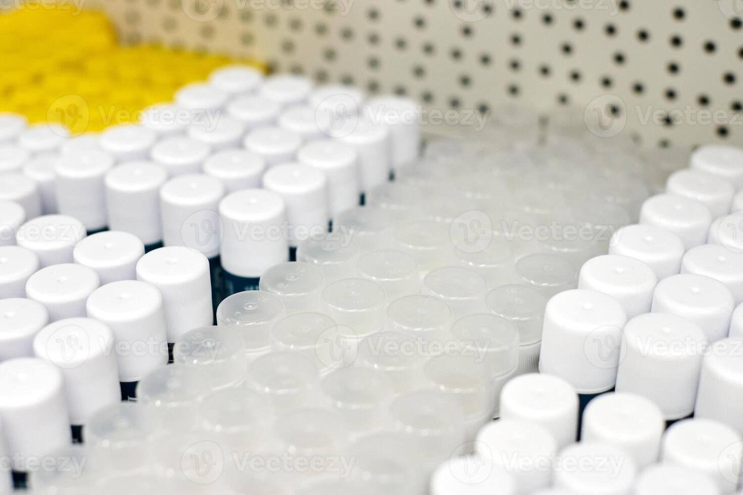 Plastic cylindrical jars with round caps in raw on shelf photo
