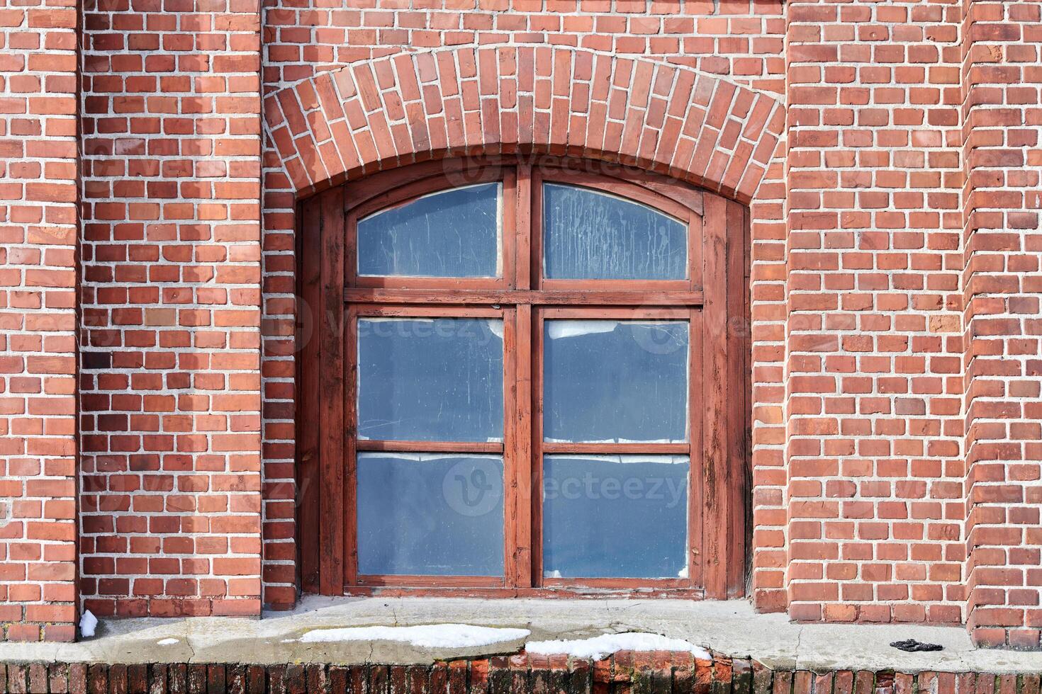 One arched glass window on old red brick wall photo