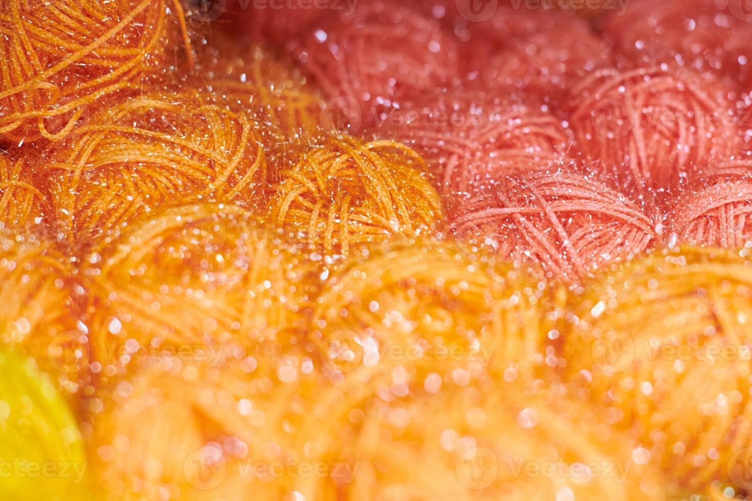 Colored orange and red yarn balls in knitting shop, macro photo