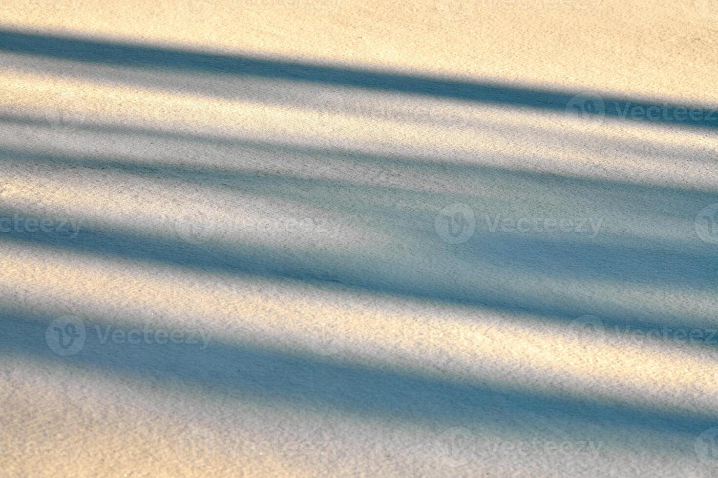 Abstract shadow lines on winter snow background photo