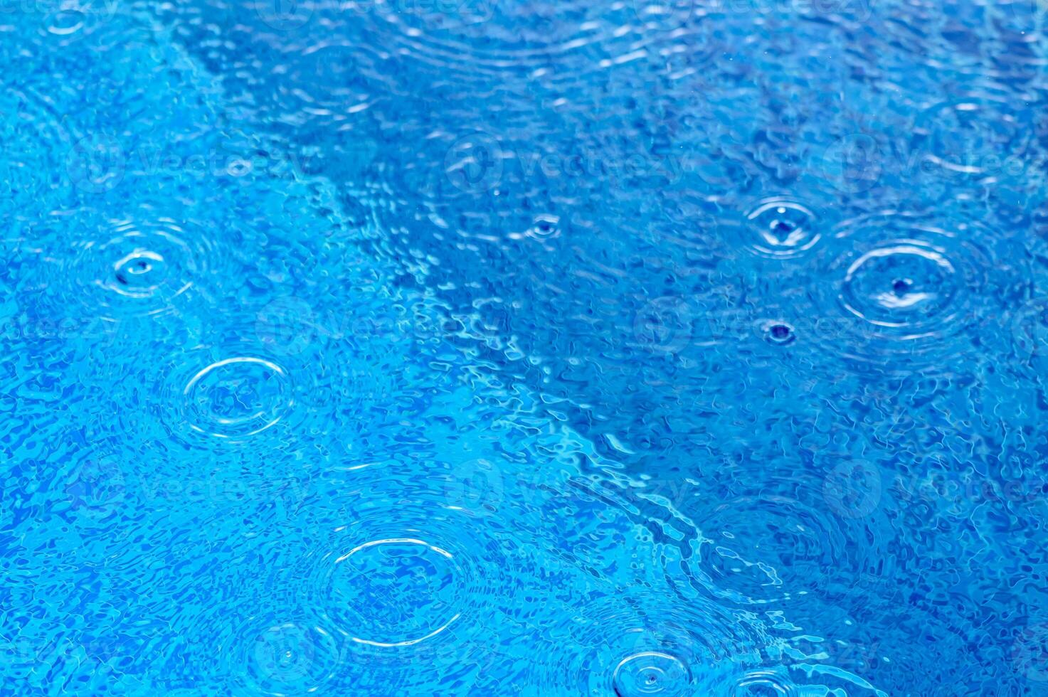 De-focused blurred transparent blue colored clear calm water surface texture with splashes and bubbles.6 photo