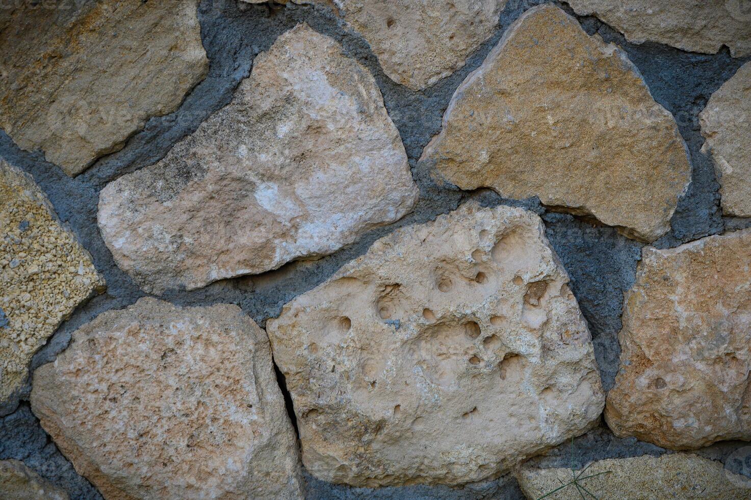 Granite stones of different shapes and colors. Wall cladding. Background selective focus with copy space. 1 photo