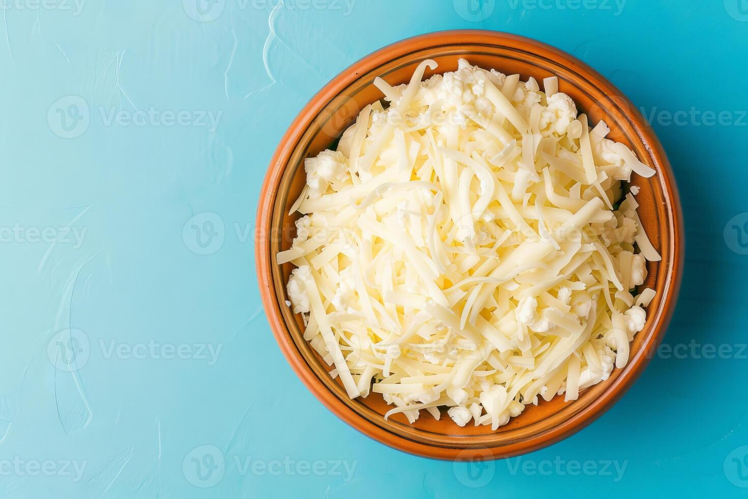 Grated mozzarella cheese in wooden bowl photo