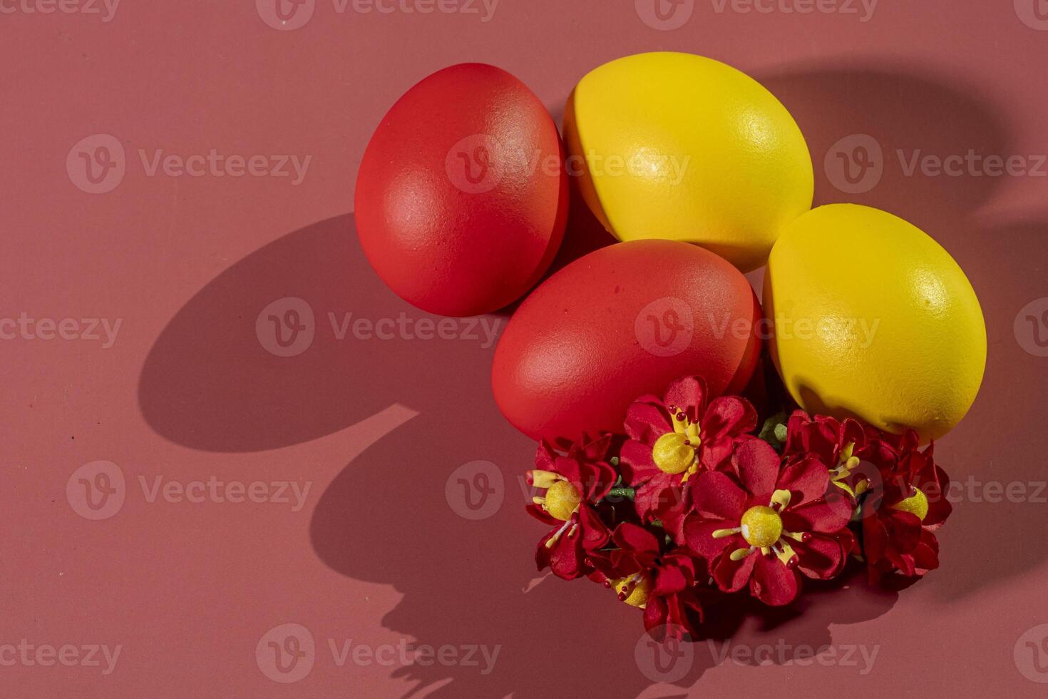 Colorful eggs, symbolizing Easter, on a colorful background and flowers photo