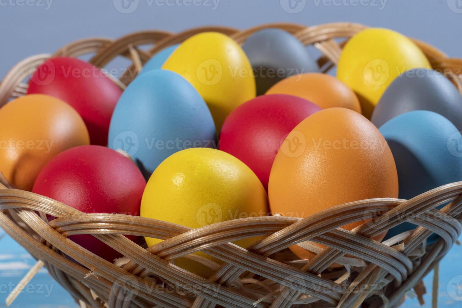 easter basket with straw and colored eggs photo