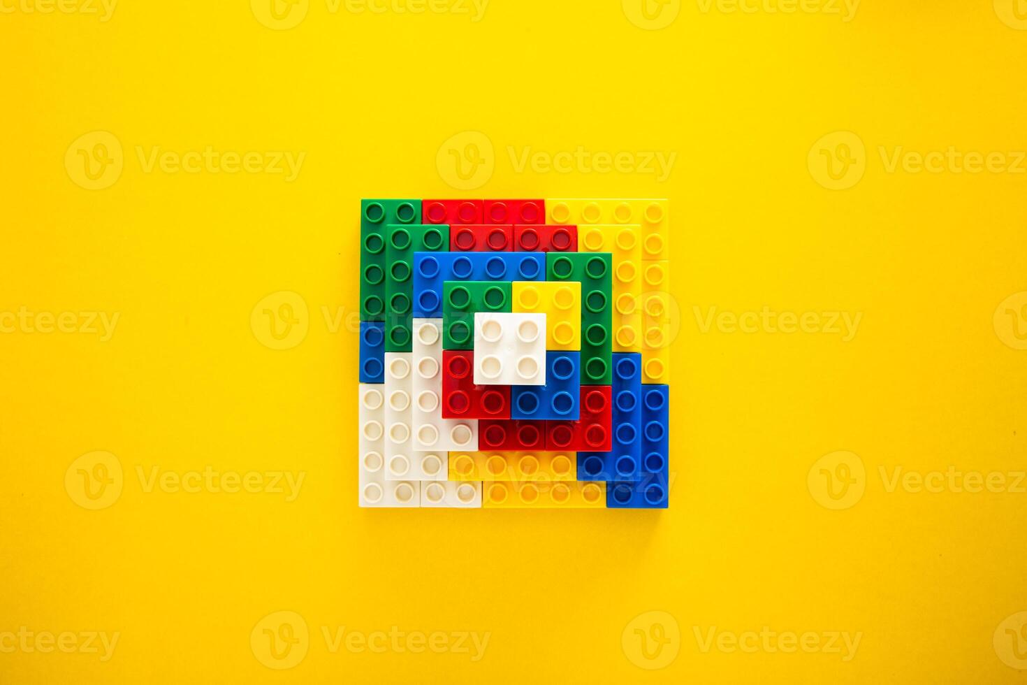 Color plastic building blocks on yellow background photo