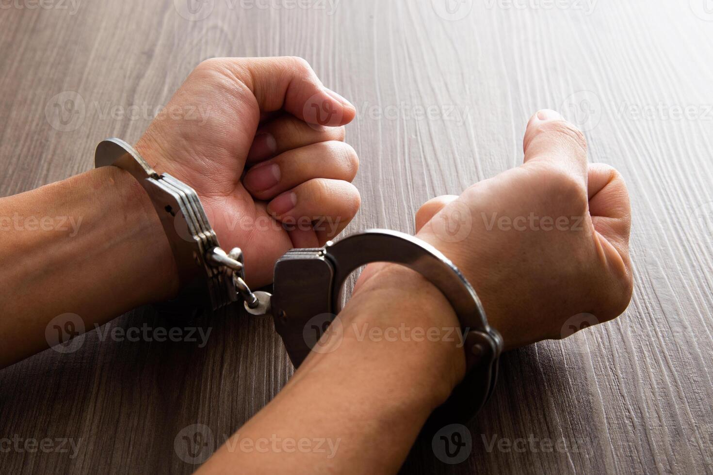 Arrested criminal hands locked in handcuffs. photo