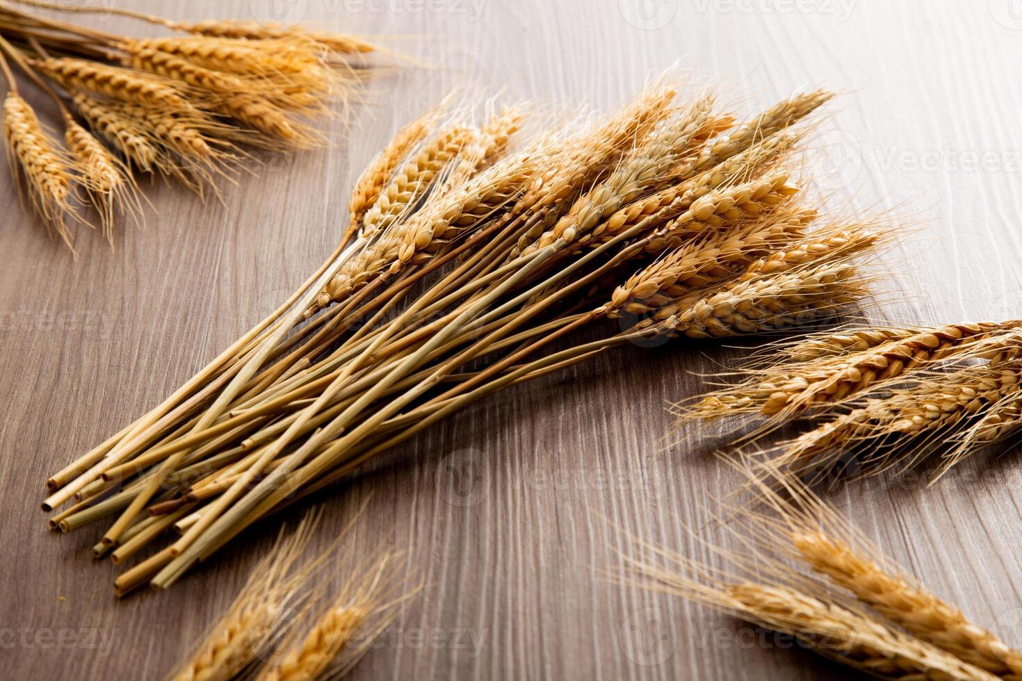 Spikelets of wheat on old wooden table background photo