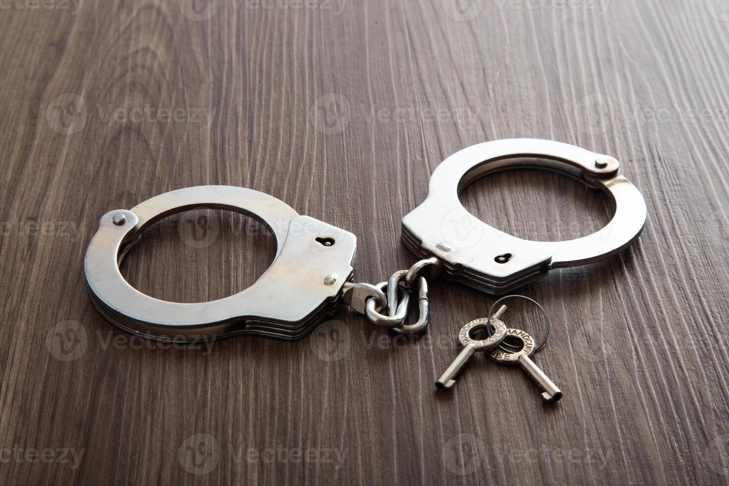 Police metal handcuffs on dark wooden background photo